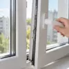 Рука на ручке открытого пластикового окна